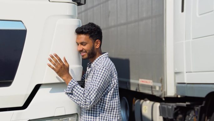 快乐的亚洲卡车司机热爱他的工作。印度卡车司机抱着他的卡车运输