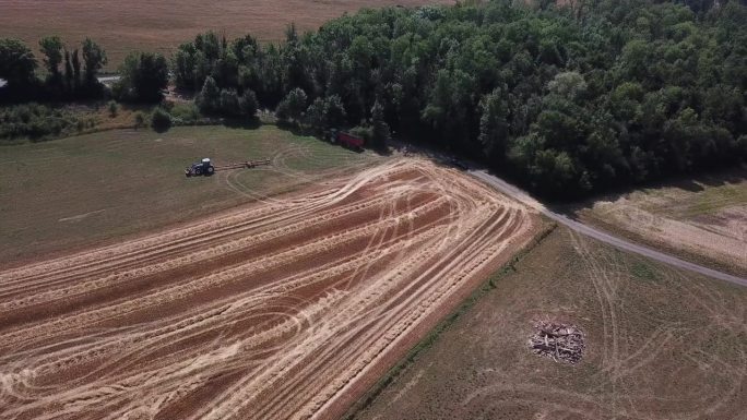 一架4K无人机在法国拍摄了两辆拖拉机在田野上工作的场景，以史诗般的景色和戏剧性的尘埃展示了农业。