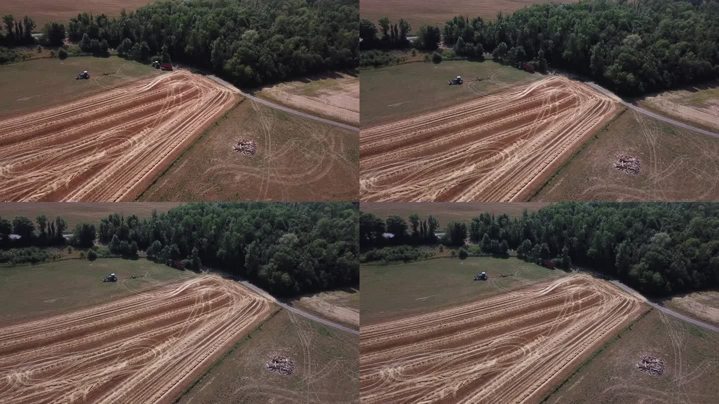 一架4K无人机在法国拍摄了两辆拖拉机在田野上工作的场景，以史诗般的景色和戏剧性的尘埃展示了农业。