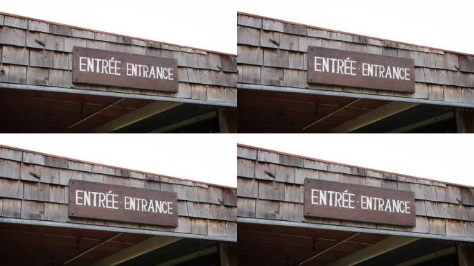 在加拿大当地一家户外农贸市场的屋顶上，一个质朴的白色油漆木制入口标志