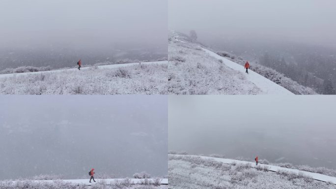 航拍男子走在新疆禾木村的风雪中