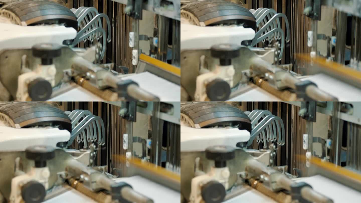 编织织机。纺织工厂。纺织工业。特写镜头。自动织布机正在织造线布。纺织厂设备。面料生产。