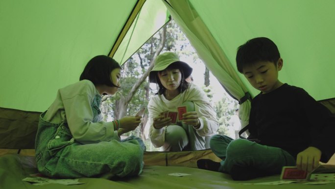 日本家庭在一起露营时玩纸牌。