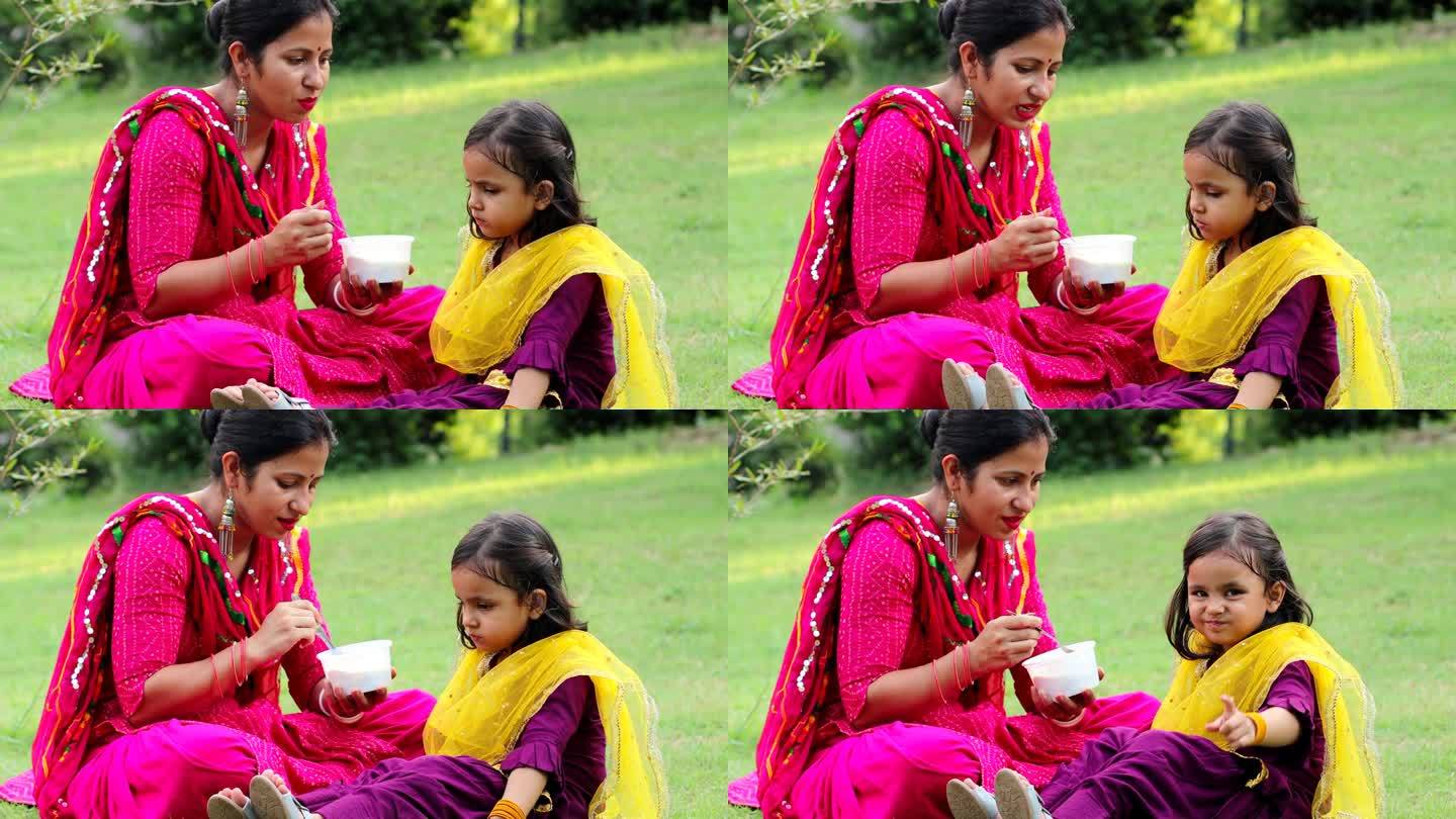 白天，一位母亲在公园里给她的小女儿喂奶
