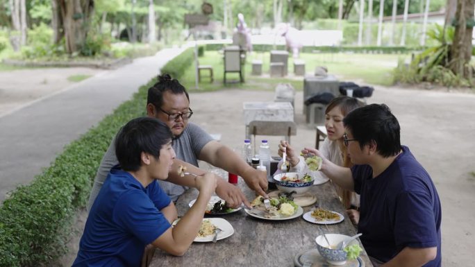 四个大学生在大学食堂外吃饭。