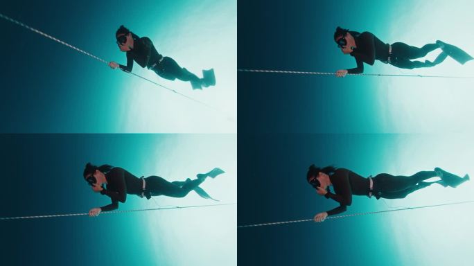 自由潜水员在绳子上锻炼。女子自由潜水运动员在开阔的海面上沿着绳索训练，然后下潜到深处，这是自由潜水训