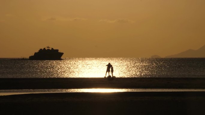 日落时分，幸福的一家人站在海滩上