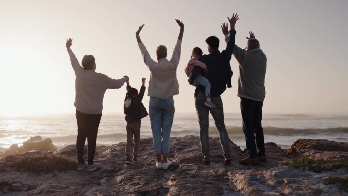 一个大家庭，带着孩子在沙滩上看日落，和祖父母一起度过暑假。快乐的爸爸、妈妈或孩子们喜欢双手抱抱，祖母