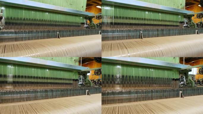 织布机。纺织厂设备。纺织厂正在工作的工业织布机。编织。
