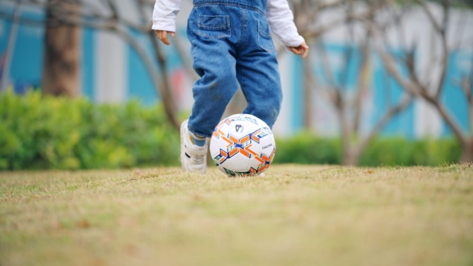 小孩踢足球开心玩耍特写
