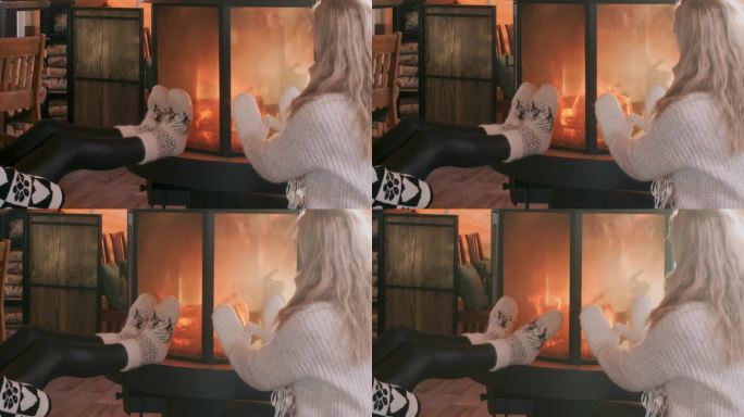 两个女人坐在客厅壁炉旁暖手暖腿。