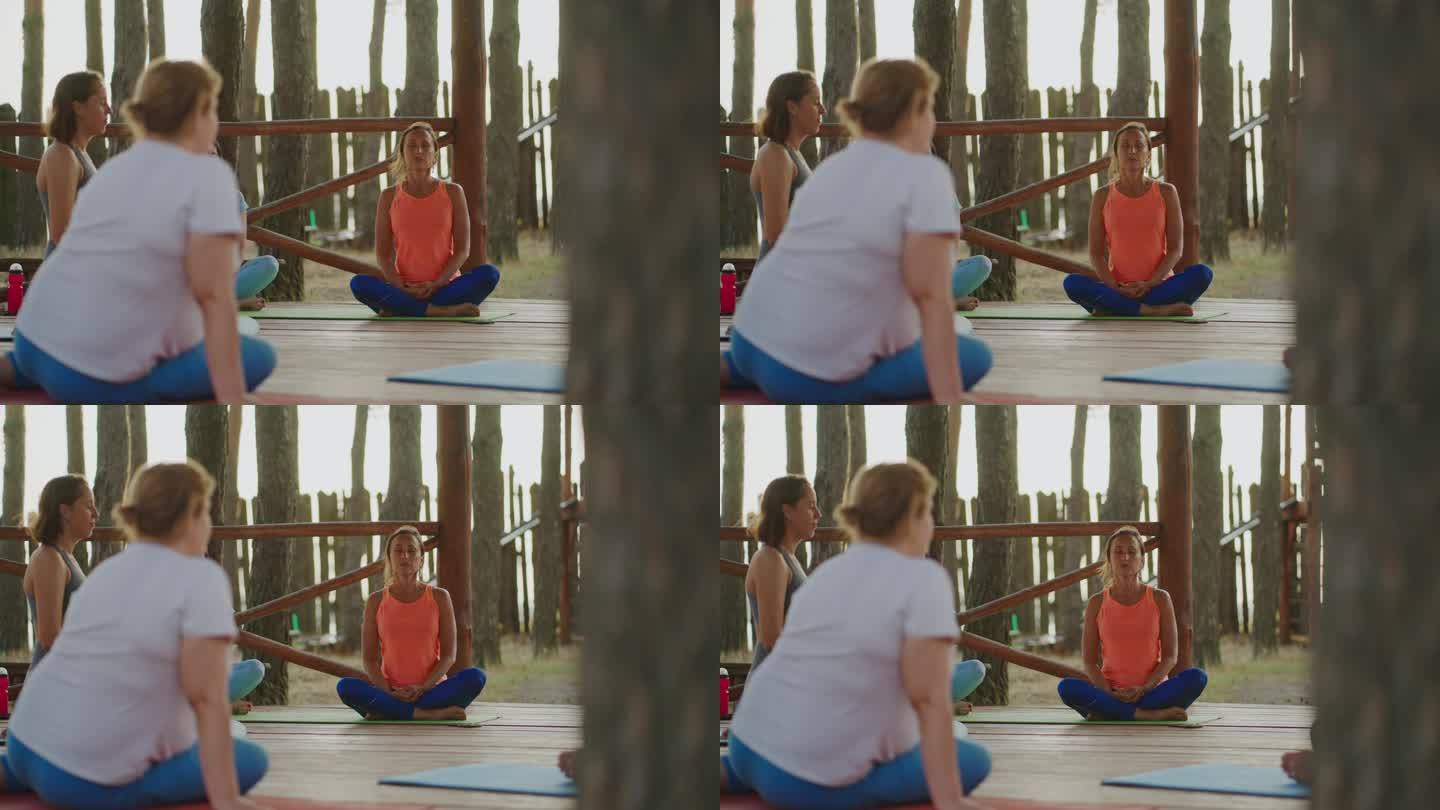 户外瑜伽课，女教练和不同的女性练习体式和呼吸练习
