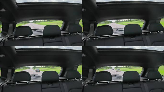 美丽的后景内饰真皮座椅和全景天窗的新黑色电动汽车行驶在高速公路上。