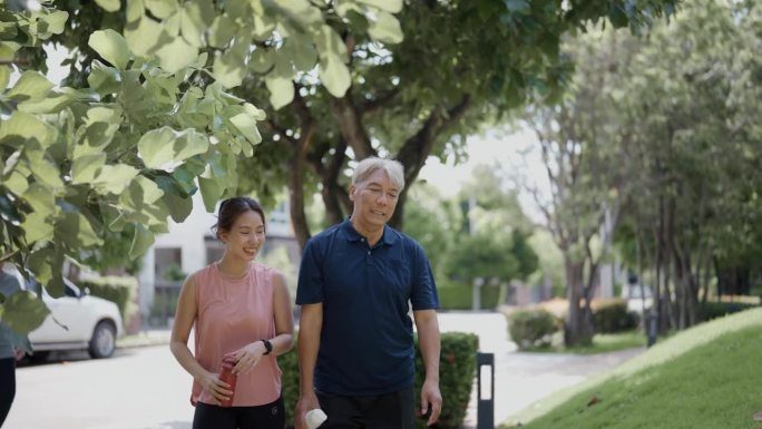 快乐的亚洲老年父亲和成年女儿在夏天的早晨一起在公园做运动。