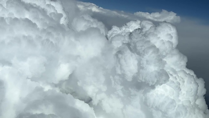 在一个阳光明媚的夏日午后，飞行员看到的雄伟的风暴积雨云。一个独特的飞行员视角。左拐。