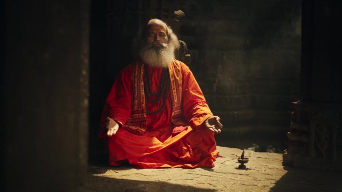 一个印度高僧在寺庙里练习瑜伽的真实照片。宁静与冥想的古代精神实践展示，寻求深刻的内心平静与启蒙