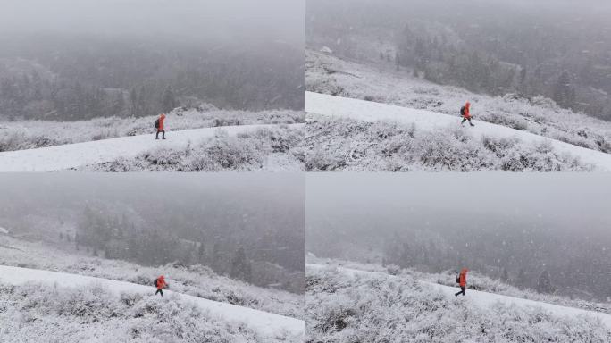 航拍男子走在新疆禾木村的风雪中