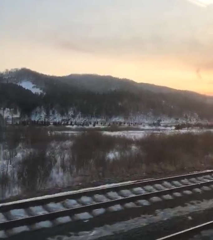 冬日黄昏下的雪覆铁路与远山