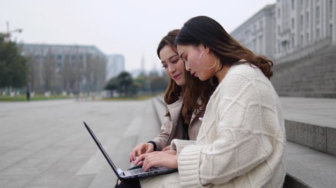 美女大学生在校园使用笔记本电脑上网学习