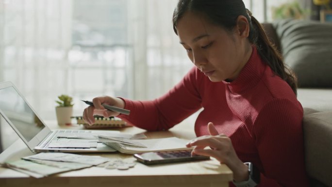 每月家庭开支的总和。女人为家庭计算财务，跟踪拍摄