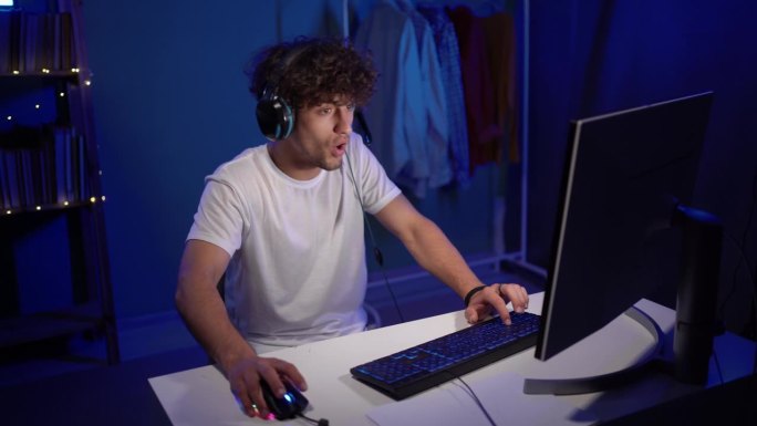 在家玩游戏。快乐的阿拉伯玩家在他的电脑上赢得了一轮在线视频游戏。穆斯林正在享受在线多人游戏冠军。