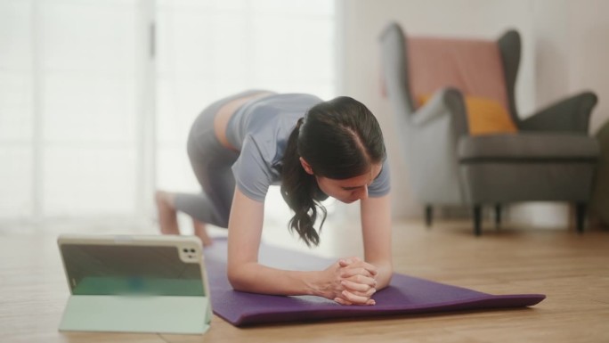 电子学习健身:年轻女性的家庭锻炼与平板电脑的虚拟教育。