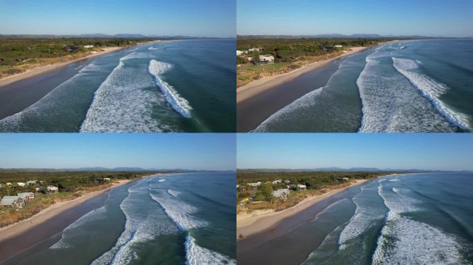 在澳大利亚新南威尔士州不伦瑞克岬的海滩上，海浪翻滚到岸边。空中的回调