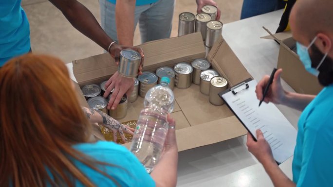 志愿者将食物和水装在盒子里等待捐赠