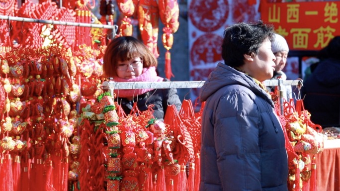 买卖过节吉祥物挂饰的商贩和顾客