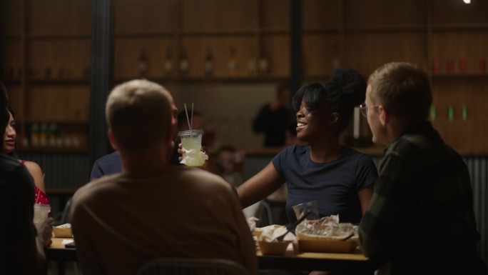 非洲裔美国妇女为朋友干杯和碰杯，与朋友共进晚餐