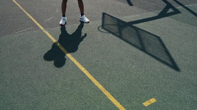一个拿着球的篮球运动员的影子