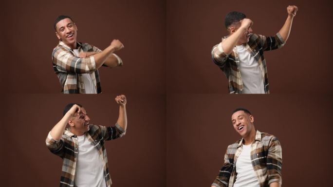 快乐的年轻非洲裔美国人跳舞在棕色的工作室背景