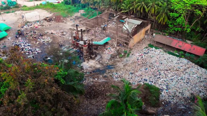 热带岛屿上的垃圾焚烧厂，热带地区污染空气和土壤的垃圾桶鸟瞰图，用明火燃烧塑料，将塑料垃圾堆积起来回收