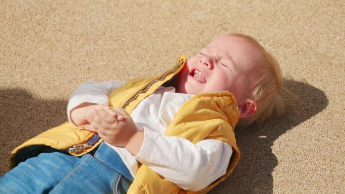小男孩躺在地上哭得很伤心。心烦意乱的孩子，负面情绪，孩子的问题