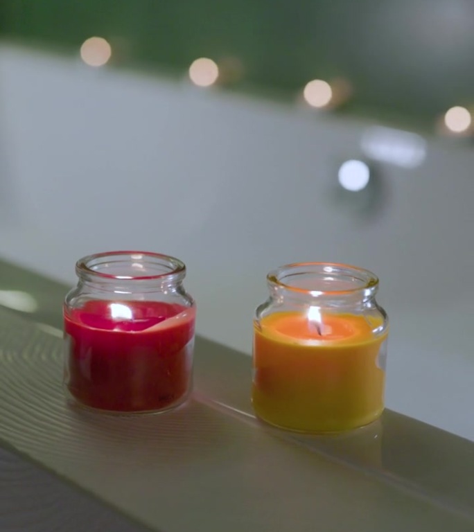 浴缸边上放着两支香薰蜡烛