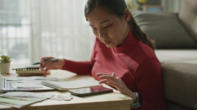 亚洲女性在家管理预算的跟踪镜头