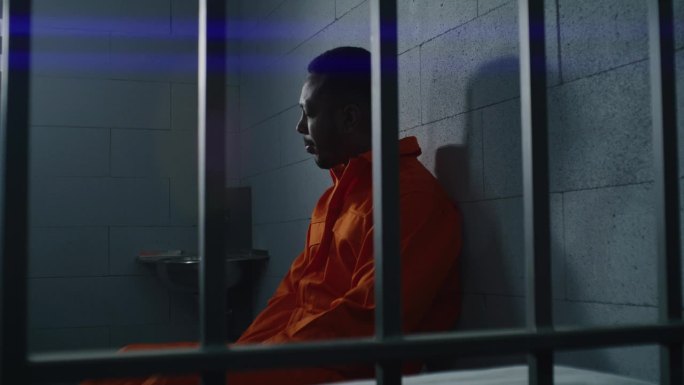 非裔美国囚犯坐在监狱床上
