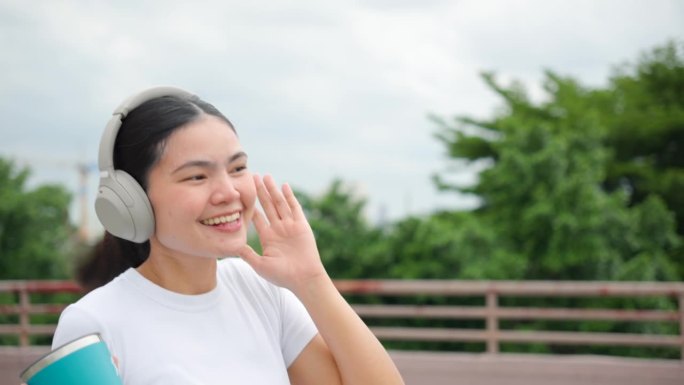 听音乐的亚洲女性室外听音乐散步边听歌边走