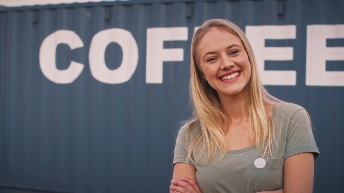 微笑的女实习生在货运业务站在集装箱