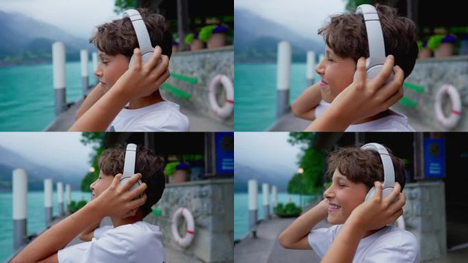 精力充沛的少年把耳机放在湖边，随着音乐的节拍跳动，特写快乐的表情