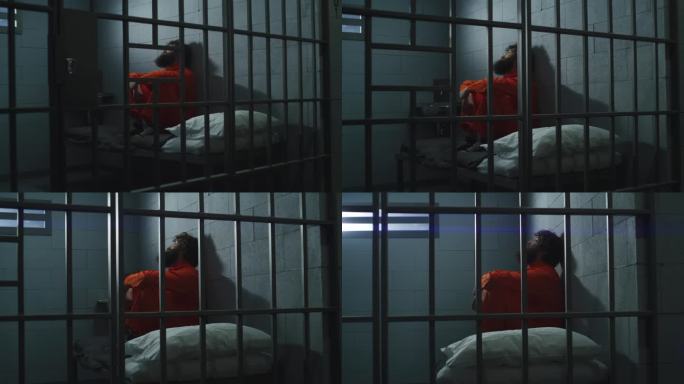 穿着橙色制服的罪犯坐在牢房的床上
