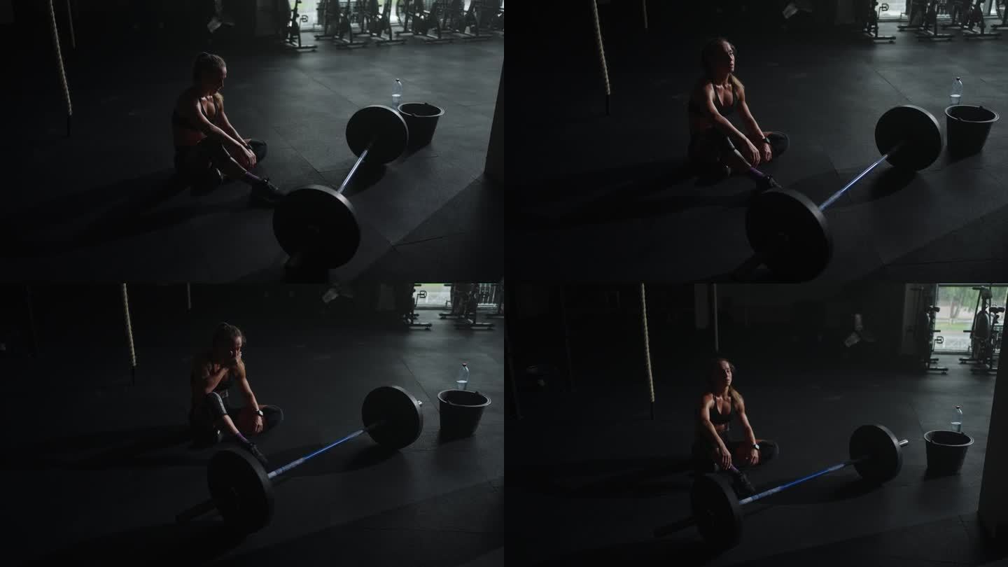 女运动员在艰苦的力量训练后休息，在健身房有动力的女举重运动员的肖像