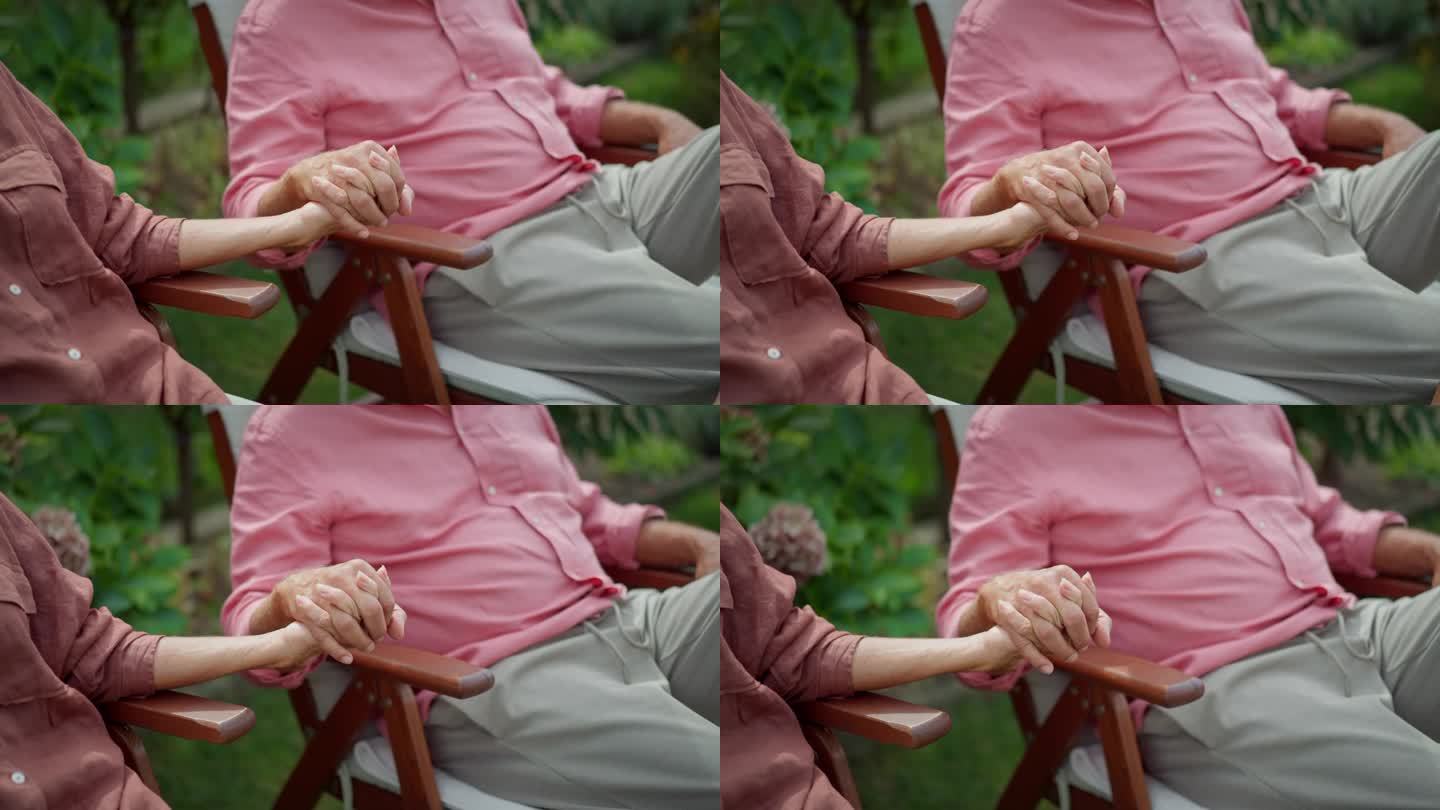 老年夫妇手牵着手的特写。