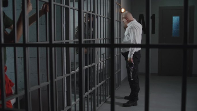 好斗的狱警在牢房里监视罪犯
