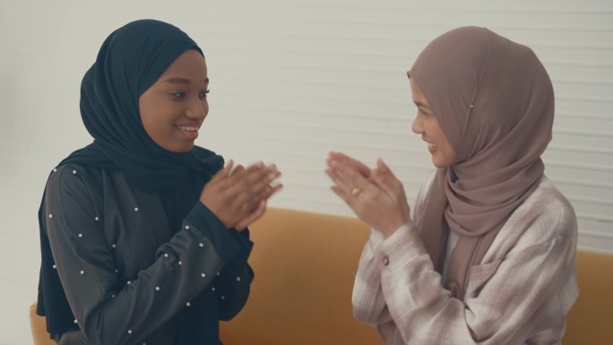 迷人的微笑美女穆斯林年轻女子正在问候她的朋友，微笑着说话。