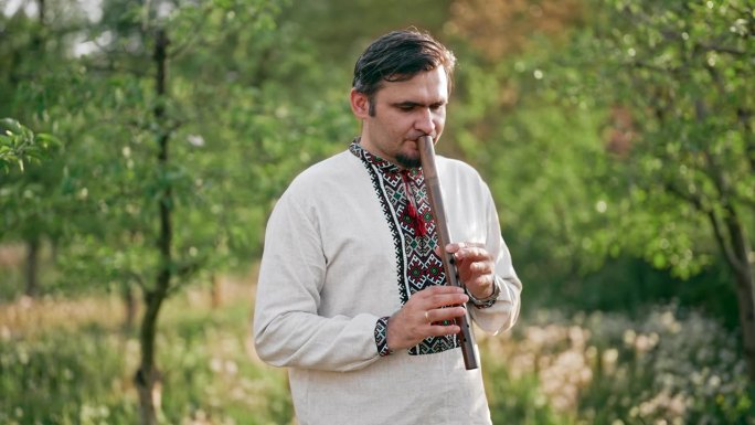 年轻人在户外演奏木管木笛-乌克兰索皮卡。民间音乐概念。乐器。身穿传统刺绣衬衫的音乐家。