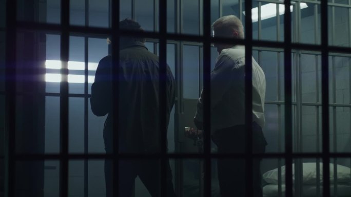 狱警用钥匙打开牢房，把男罪犯锁在里面