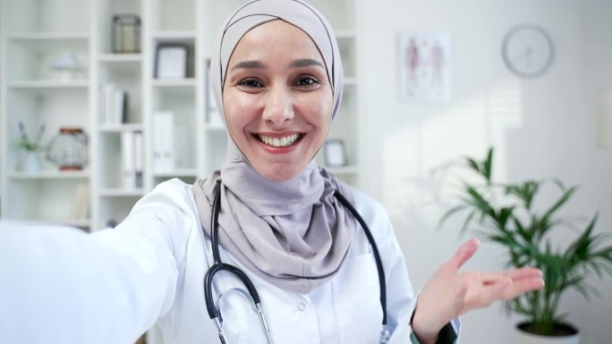 POV智能手机前置摄像头视图。快乐的穆斯林女医生在医院诊所视频通话