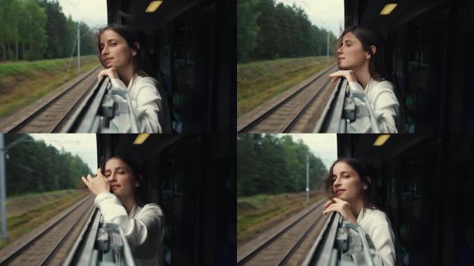 火车行驶时，年轻的长发女子或女孩从打开的车窗向外看。头发在风中飘动。喜欢坐火车旅行，夏天去山里旅行。