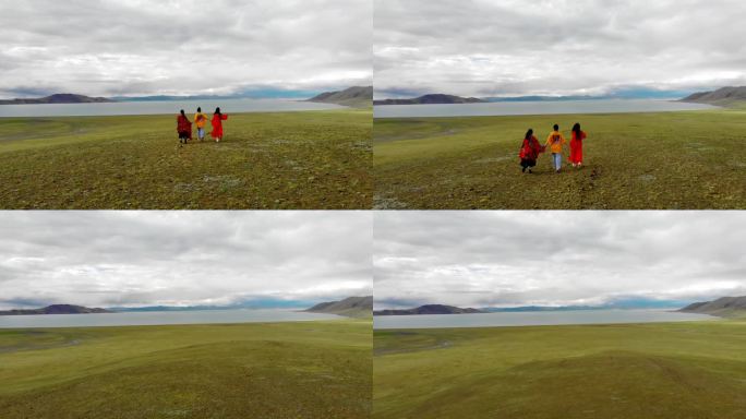 航拍旅行女孩在西藏草原上向湖面奔跑4K